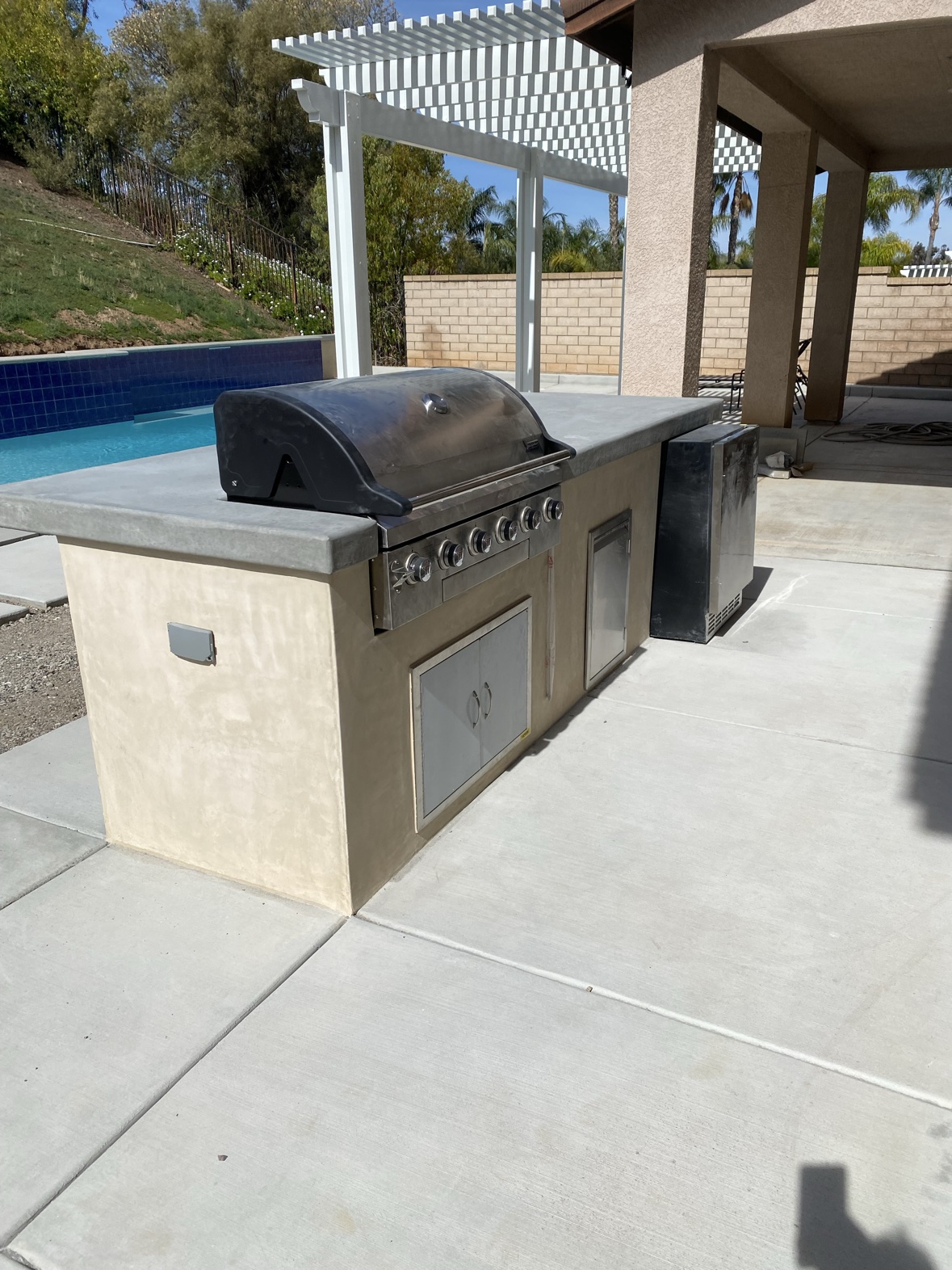 Concrete patio with outdoor kitchen island and fire pit area